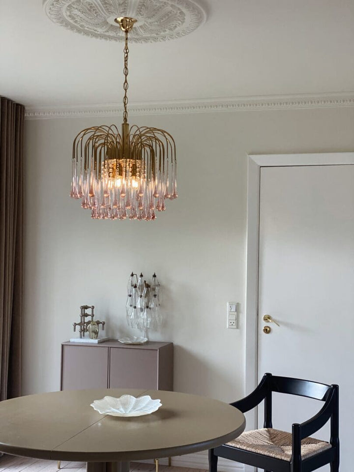 Dining room with a chandelier, table, and chairs.