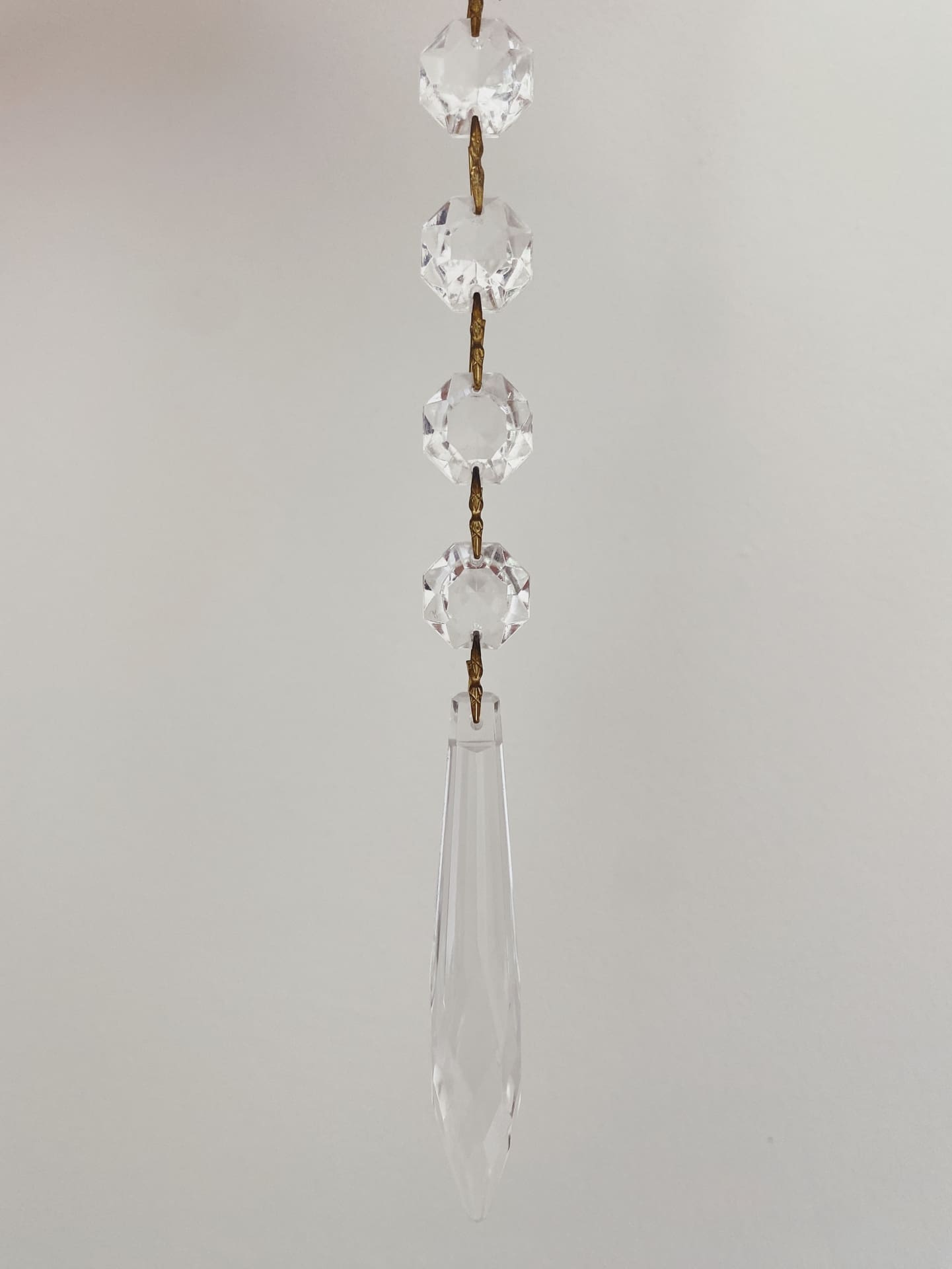 Crystal hanging decoration with teardrop shape on a plain background