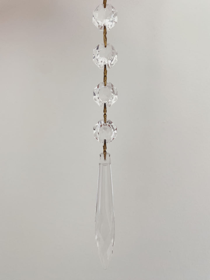 Crystal hanging decoration with teardrop shape on a plain background